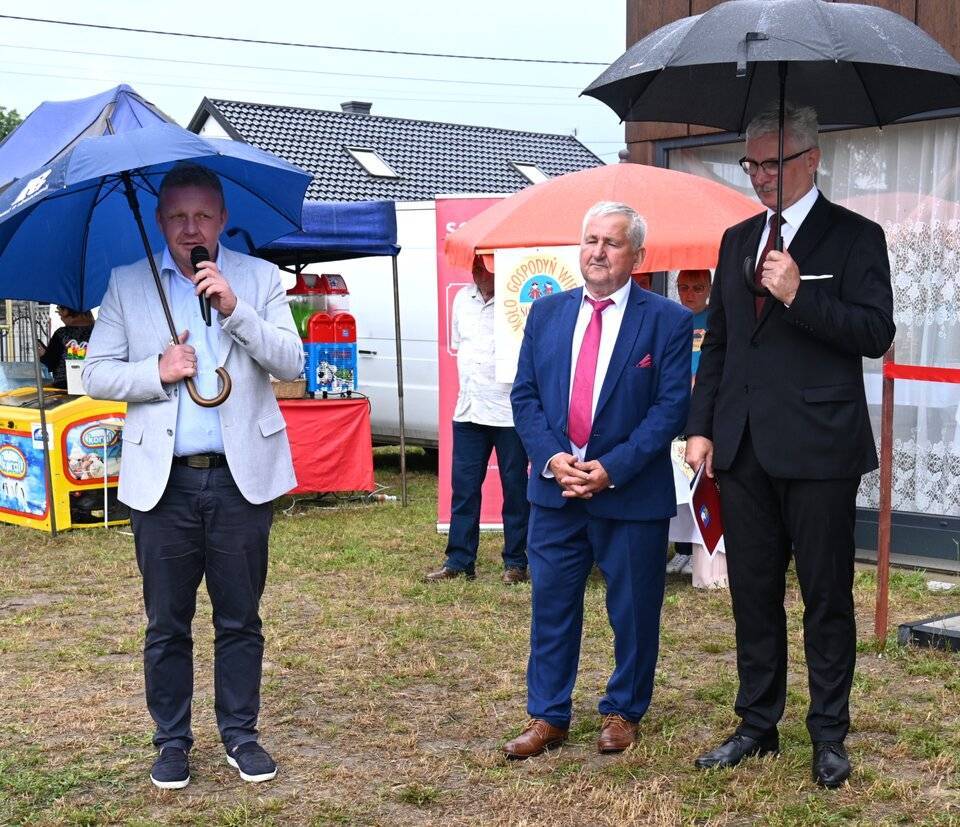 3-mezczyzn-stoi-na-placu-przed-swietlica-pada-deszcz-maja-w-rekach-parasol_20250714-114736_1